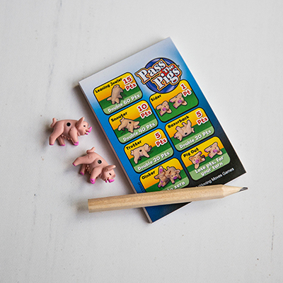 PASS THE PIGS<sup>&reg;</sup> Dice Game - Toss these tiny pig "dice" and and score points for each pose in this fun family dice game.  Game includes plastic "Pig Sty" dice cup with lid, 2 pig dice, 1 pencil, pig scoring guide and pad and illustrated instructions.  Ages 7 and up. 2 or more players.